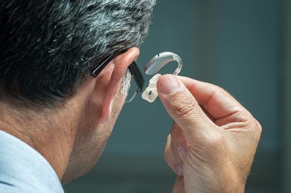 Hearing aid specialist fitting a hearing aid